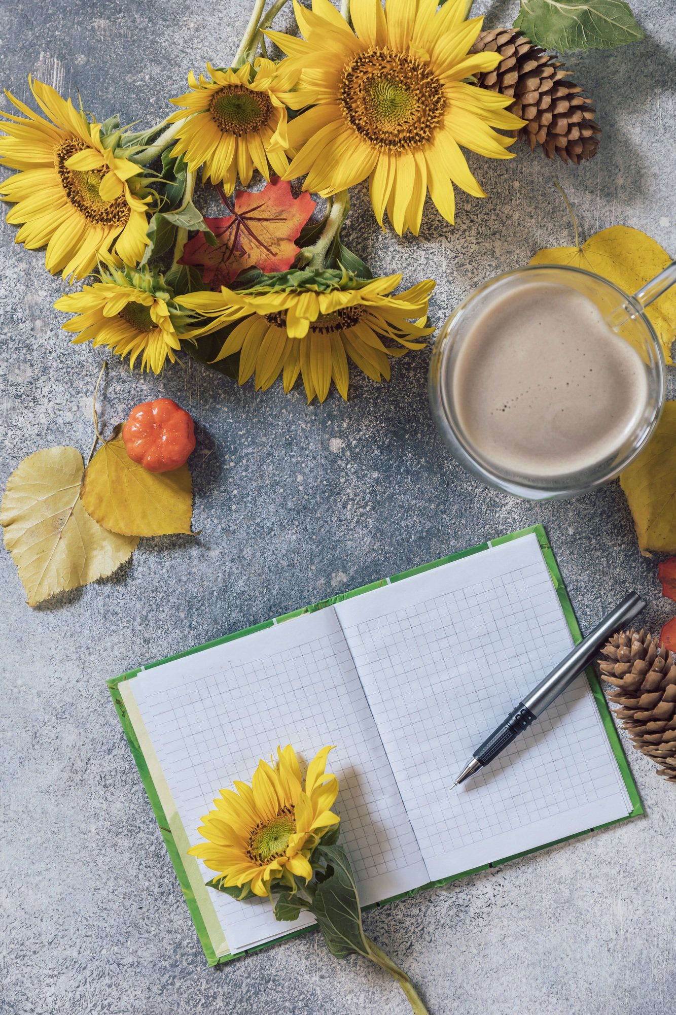 Good Morning. To do list concept. A bouquet of large sunflowers, coffee cup and empty notebook.