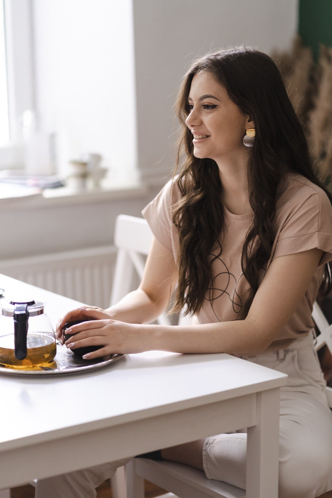 Mother with daughter drinking tea together at the kitchen at table