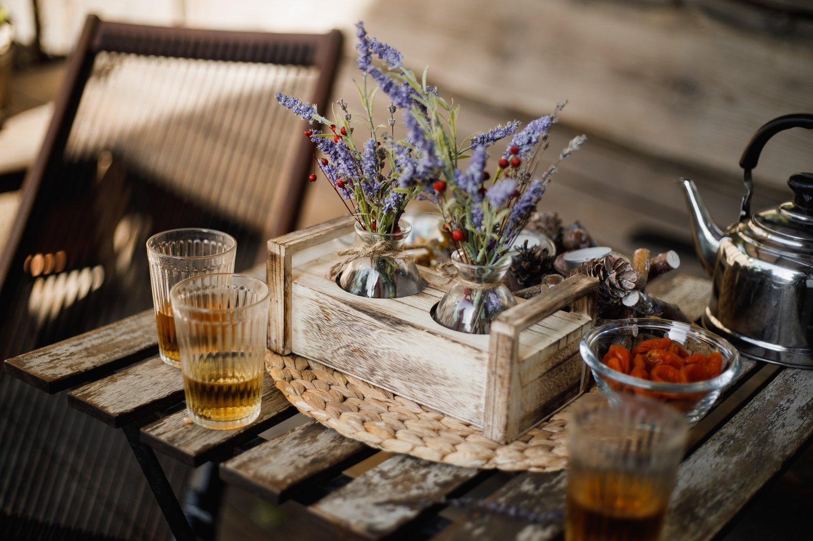The wooden coffee table with cups of tea with a kettle and herbs on it
